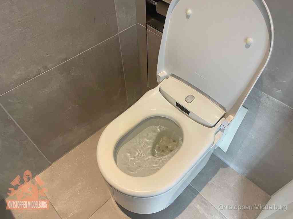 Een toiletpot vol troebel water met drijvend papier en restanten, de meest voorkomende oorzaak van een verstopte wc in Middelburg