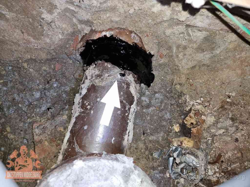 Een oude gres rioolbuis met een beschadigde koppeling onder de vloer, oorzaak van terugkerende structurele wc-problemen in Middelburg
