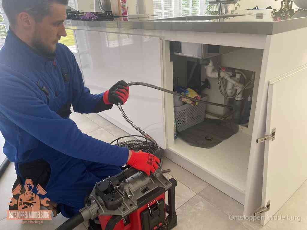 Een monteur reinigt de keukenafvoer grondig met een veermachine om terugkerende gootsteenverstoppingen te voorkomen in Middelburg