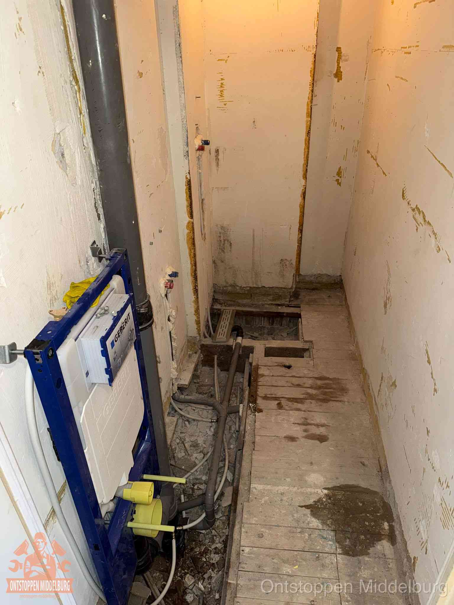 Een opgebroken toiletruimte tijdens renovatie met een Geberit inbouwreservoir en blootliggende oude afvoerleidingen, typisch voor oudere woningen in Middelburg